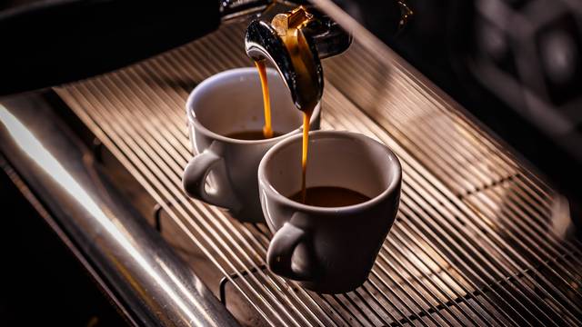 Zwei Tassen Espresso, die frisch aus einer Espressomaschine laufen