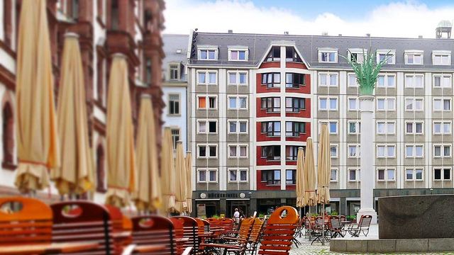 Blick auf den Nikolaikirchhof in Leipzig mit Stühlen und Sonnenschirmen